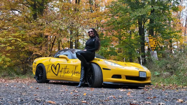 Chelsea seated on the Corvette's front fender.
